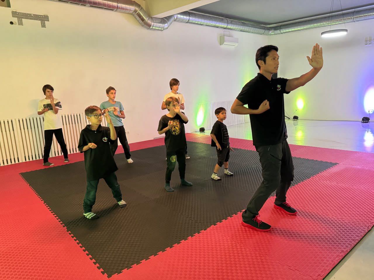 Trainer zeigt einer Kindergruppe eine Wing-Tsun-Haltung