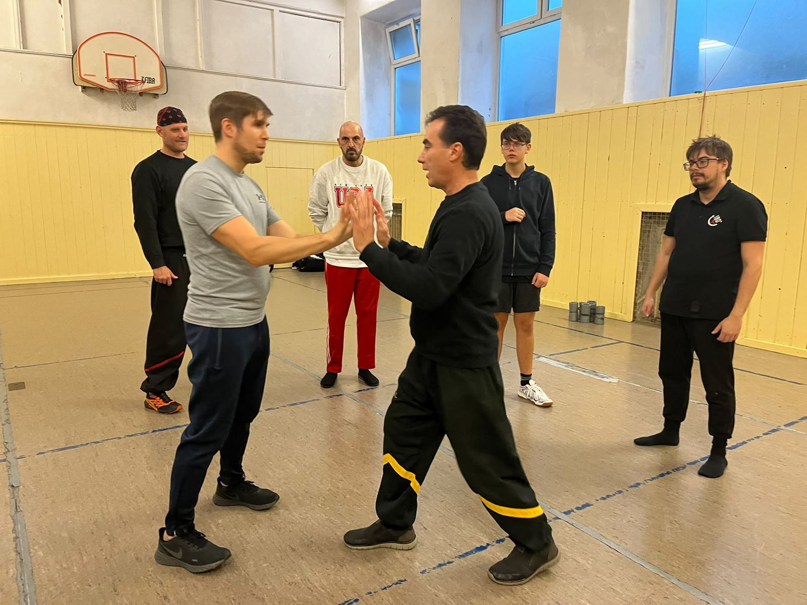 Trainer und Schüler üben Chi Sao, umringt von der Trainingsgruppe
